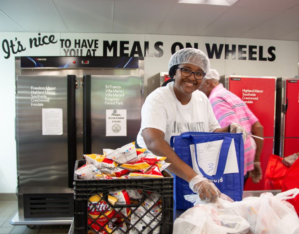 Regions Bank employee volunteering in the Meals on Wheels Kitchen.